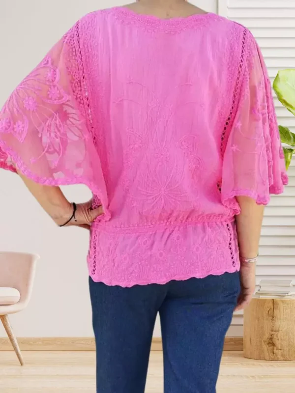 blouse-en-dentelle-rose-ds Blouse en dentelle et brodée avec manches chauve-souris et taille resserrée, silhouette féminine et élégante, vue de dos, coloris : rose fuchsia