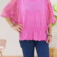 Blouse en dentelle et brodée avec manches chauve-souris transparentes, taille volantée et col en V vue de face, coloris : rose fuchsia