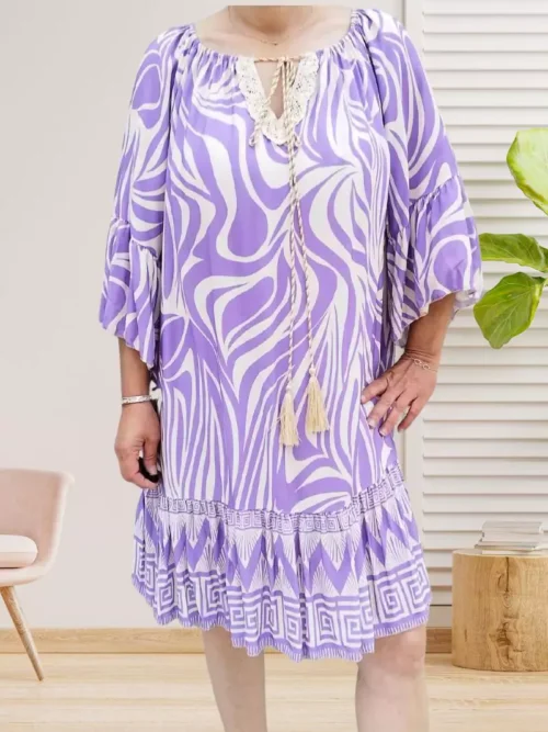 Robe à volant pompon parme, col à épaule dénudée ou échancrure arrondie, décolleté en dentelle, manches 3/4 volantées. Taille unique (36-42/44), 100% viscose vue devant