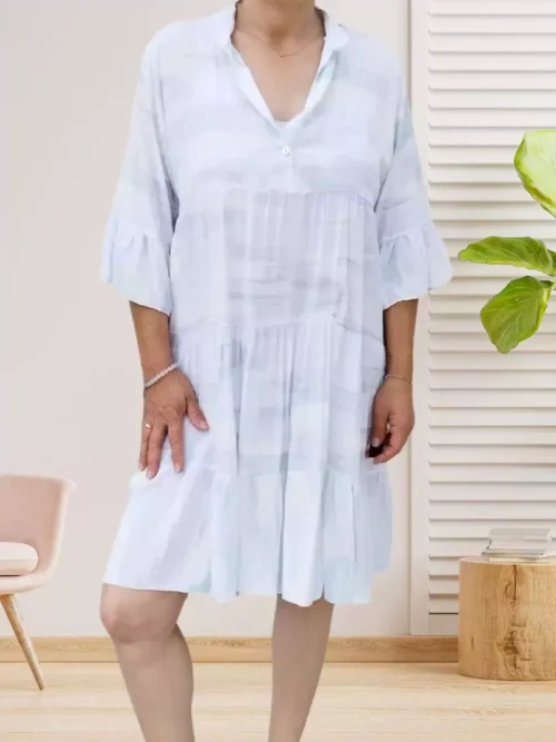 Robe large évasée à motifs, blanc, col mao, patte de boutonnage, volants aux manches et à la base, coupe fluide et élégante. Taille unique 36 au 40/42 vue devant