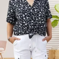 Chemise à fleurs manches courtes, coupe fluide et fermeture par boutonnage, look élégant et polyvalent, vue de face, nouée à la taille, coloris : noir.