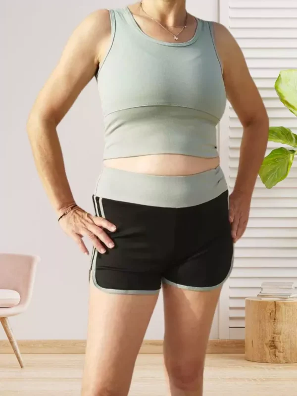 ensemble-de-sport-short-vert-dv Ensemble de sport respirant avec brassière sans manches et short bicolore fluide avec large élastique à la taille, vert et noir, vue devant